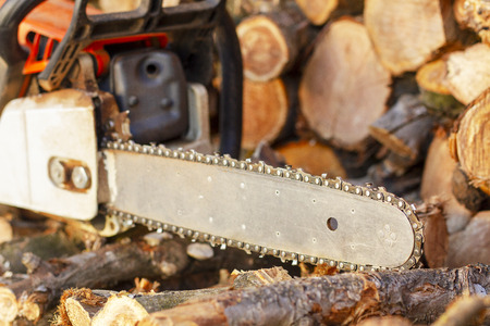 Chainsaw. Chainsaw close up. Chainsaw on the background of firewood.