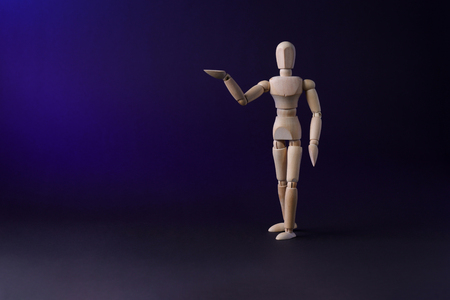A wooden mannequin shows with his hand. The concept of pointing at someone with your finger. The mannequin will stretch out his hand. Wooden man concept. Wooden mannequinの写真素材