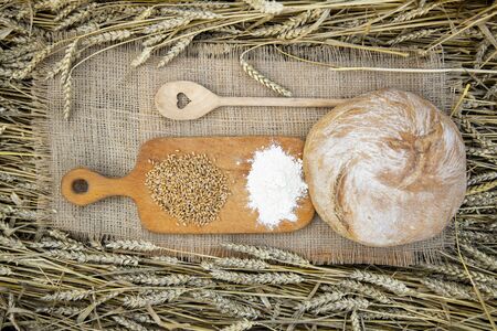 Basket with bread on the background of wheat ears. Basket with bread. Bakery products in a basket on a wheat field.の写真素材