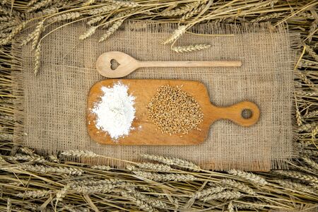 Basket with bread on the background of wheat ears. Basket with bread. Bakery products in a basket on a wheat field.の写真素材