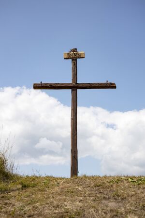 The Cross with bright sun and clouds in the background. Wood cross on blue sky. Christian background.の写真素材