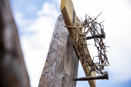 The Cross with bright sun and clouds in the background. Wood cross on blue sky. Christian background.の写真素材