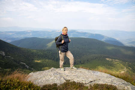 Hiker with backpack relaxing on top of the mountain.の写真素材