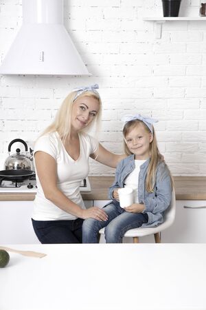 Mom with daughter in the kitchen. Family, cooking and people concept - happy mother with little daughter making cookies and having fun at home kitchenの写真素材