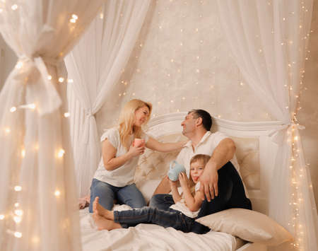 Happy playful young man and woman playing pillow fight at home, laughing loving couple having fun in bedroom, smiling wife and husband spending leisure free time together, enjoying weekendの写真素材