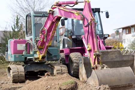 pink excavator in the heap of sand