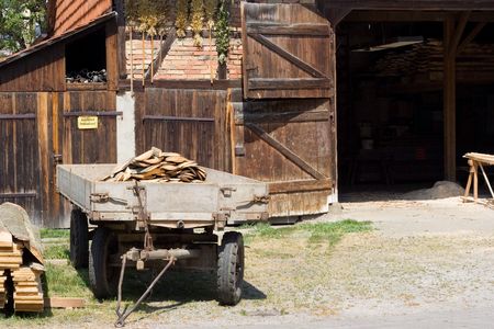 old cart in front on the old barnの写真素材