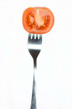 fresh tomato on fork isolated on whiteの写真素材