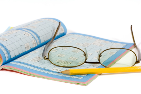 eyeglasses, pencil and crossword isolated on whiteの写真素材