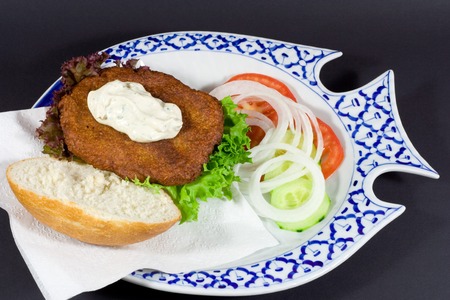 fishburger on the plate isolated on blackの写真素材