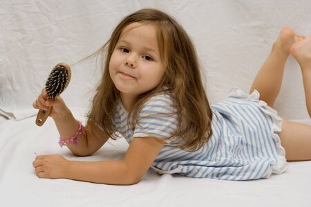 the little cute girl brushing her hairの写真素材