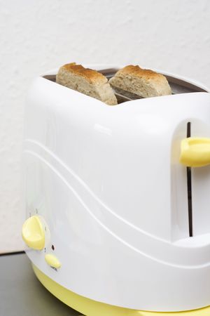 white and yellow toaster with toasts in the kitchen