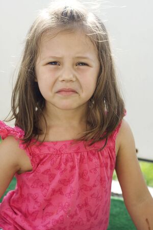 little girl wearing pink shirt making faces