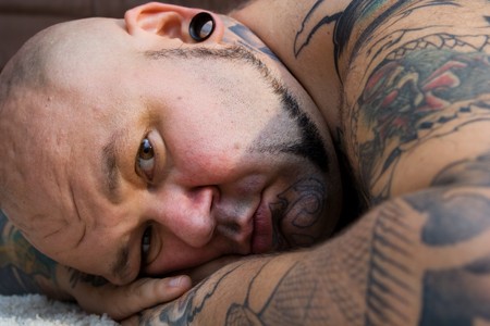 portrait of a bald man with tattoos