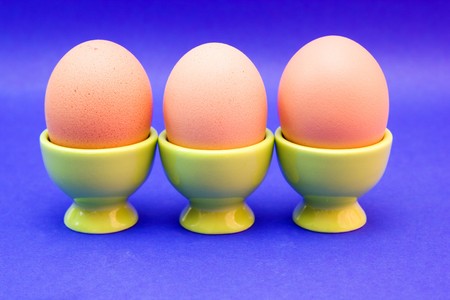 egg in green eggcup  isolated on blue. easterの写真素材