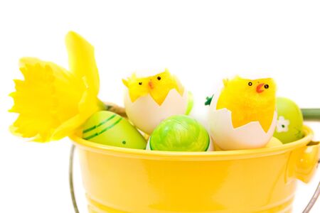 colorful easter eggs in bucket isolated on whiteの写真素材