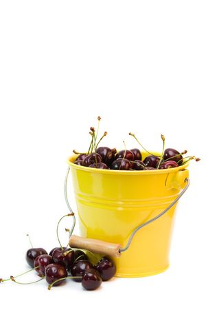 red cherries in a bucket isolated on whiteの写真素材