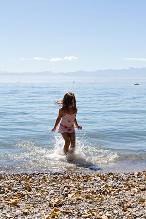 little cute girl playing on the beachの写真素材