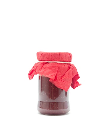 Glass pot with strawberry jam isolated on white の写真素材