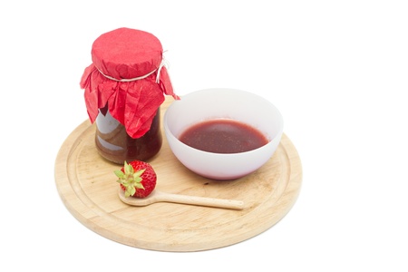 Glass pot with strawberry jam isolated on whiteの写真素材