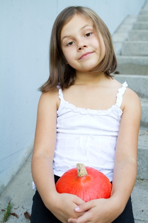 Caucasian girl holding pumpkin in her handsの写真素材