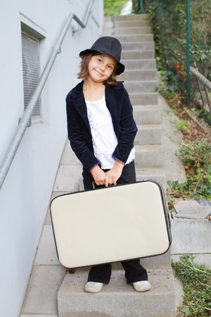 Lonely girl wearing a hat with suitcase の写真素材
