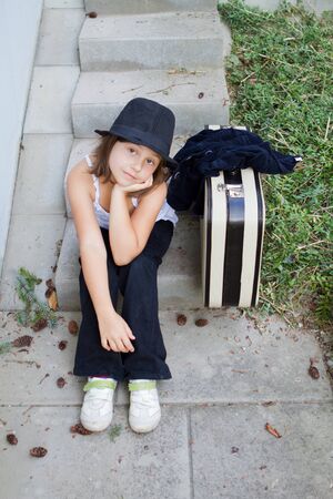 Lonely girl wearing a hat with suitcase の写真素材
