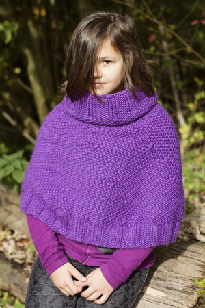 the portrait of a teenage girl wearing purple ponchoの写真素材