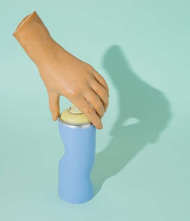 Distorted spray and hand touching the tip. Conceptual blue background.の写真素材