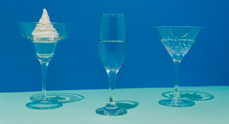 Champagne and cream in a glass. Background in two colors of blue. Conceptual setting and minimalism.
