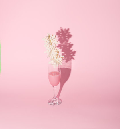 New Year's decoration on a pastel pink background. Conceptual setting. Champagne in a glass.の写真素材