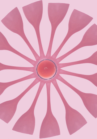 Shadow of liquid in a champagne glass placed in a circle and reminiscent of a flower. Conceptual setting on a pink background.の写真素材