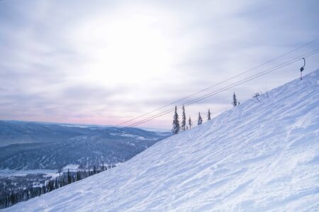 Ski lift with snowy trees and blue sky. Sheregesh landscape.の写真素材