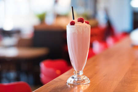 Iced milkshake with raspberry syrup topped with whipped creamの写真素材