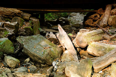 Large stones under a wooden bridge in the summer forest, Sochi, Russia. Bottom view of large boulders.の写真素材