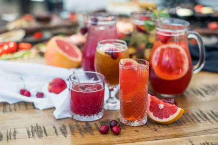 A composition of glass decanters and glasses with refreshing soft drinks made from fruits and berries.の写真素材