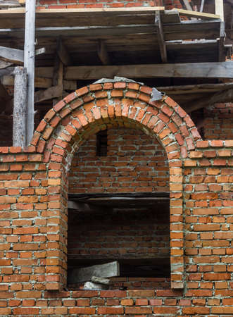 construction of a bell tower and a church. Brick wall. Wooden scaffoldingの写真素材