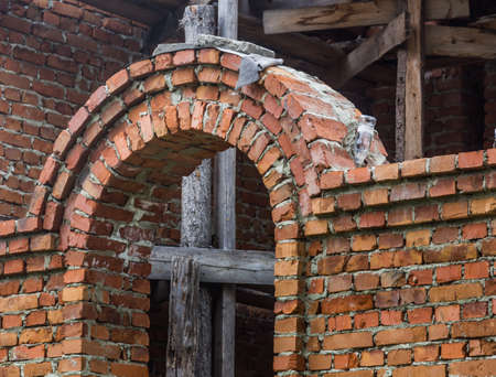 construction of a bell tower and a church. Brick wall. Wooden scaffoldingの写真素材