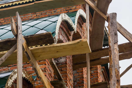 construction of a bell tower and a church. Brick wall. Wooden scaffolding
