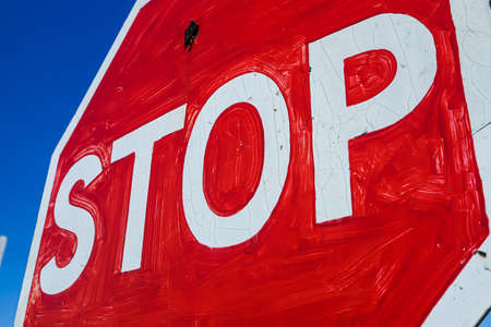 old stop sign on a background of blue sky with cloudsの写真素材