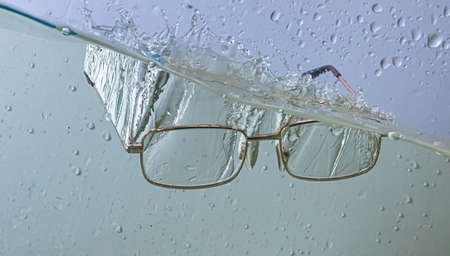 glasses fall into the water. sprays, drops and bubblesの写真素材