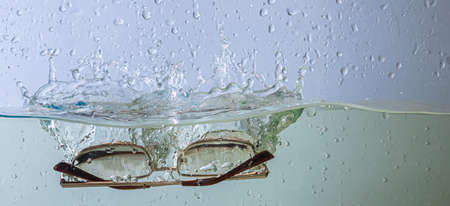 glasses fall into the water. sprays, drops and bubblesの写真素材