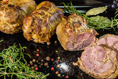 meat dish baked in the oven decorated with spices and rosemary on a dark backgroundの写真素材