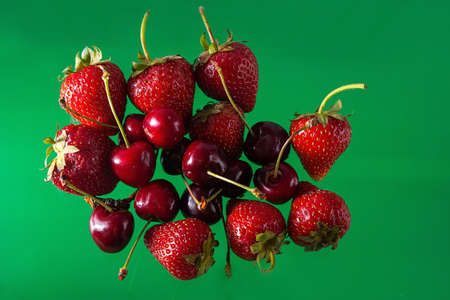 Ripe strawberries and cherries on a solid background, healthy vegetarian food. Beautifulの写真素材
