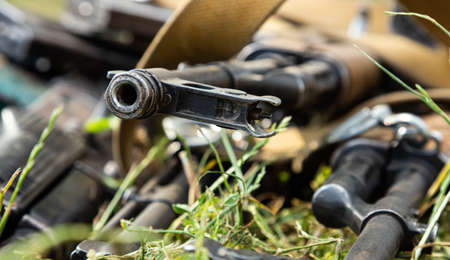 Military machine gun lies on the dry grass in the fieldの写真素材