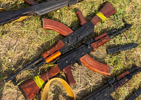 Military machine gun lies on the dry grass in the fieldの写真素材