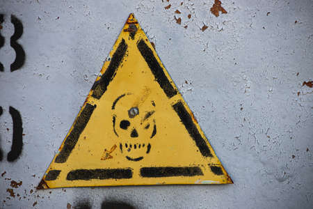 yellow danger warning sign with skull on the transformer boothの写真素材