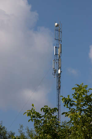 TV tower, mobile phone tower over countryside on sky background with cloudsの写真素材