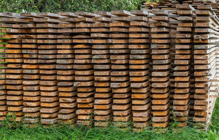Piles of wooden boards in the sawmill, planking. Warehouse for sawing boards on a sawmill outdoors. Wood timber stack of wooden blanks construction material. Industry.の写真素材