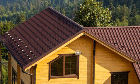 roof covered with metal tiles, roofing, wooden house.